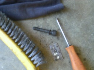 A razor and brush for cleaning, a CV bolt, and a screwdriver for cleaning the inside of CV bolts. 