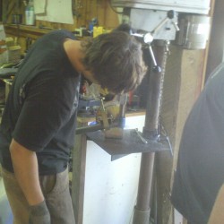 Paul using the drill press for notching cage tubing.