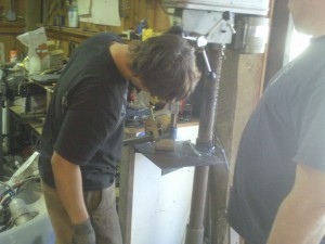 Paul using the drill press for notching cage tubing.